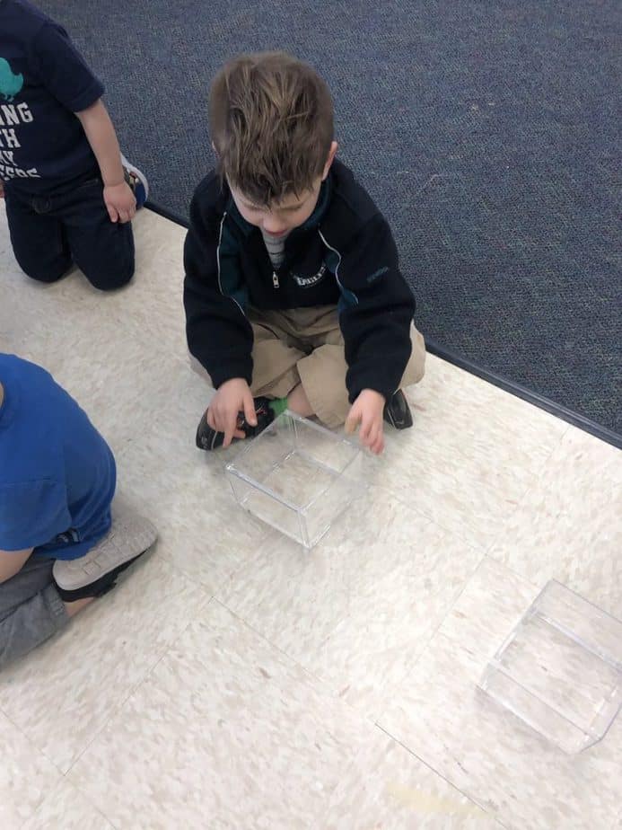 child working on hands-on project on the classroom floor