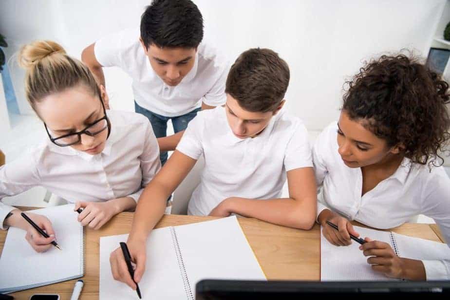 students huddled around one another, working on a project