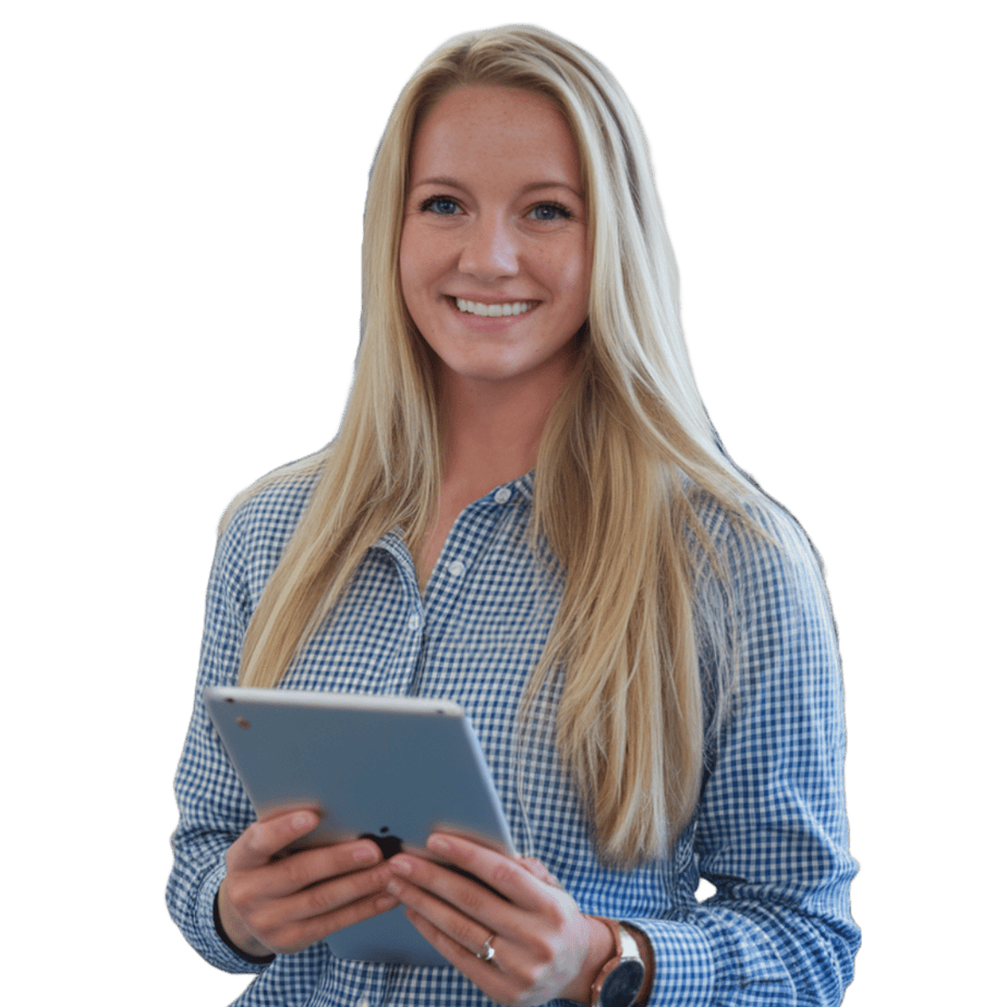 Smiling woman with long blonde hair, wearing a blue checkered shirt, holds a tablet in her hands. She stands against a plain background.